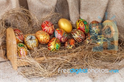 Colorful Painted Easter Egg On Hay In Wooden Shelf Stock Photo