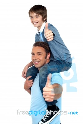 Confident Father Carrying His Son On Shoulder Stock Photo