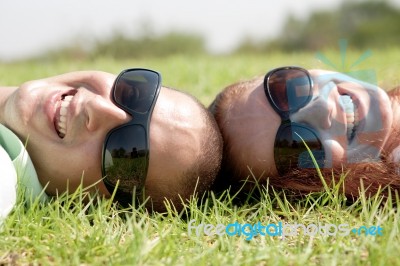 Couple Laying On Lawn Stock Photo