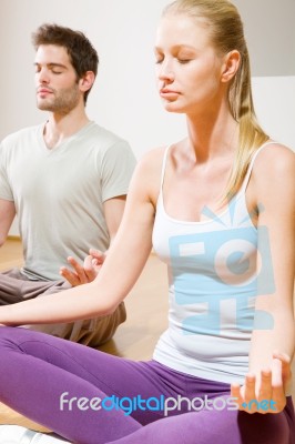 Couple Sitting On Floor Doing Yoga Stock Photo