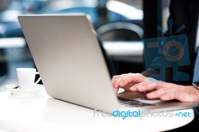 Cropped Image Of Man Working On Laptop Stock Photo