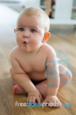 Cute Smiling Baby Sitting At Home Stock Photo