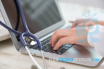 Doctor Hands Typing On Laptop Keyboard Stock Photo