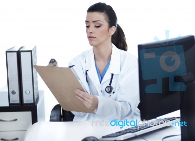 Doctor Woman Sitting On Her Office Making Notes Stock Photo