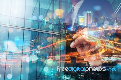 Double Exposure Of Businessman Draw Something With City Traffic Scene At Night And Glass Decorated Building Stock Photo
