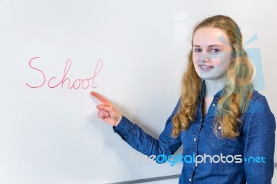 Dutch Teenage Girl Pointing At Word School Written On White Boar… Stock Photo