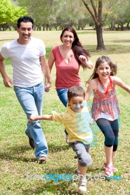 Family Playing In The Green Field Stock Photo