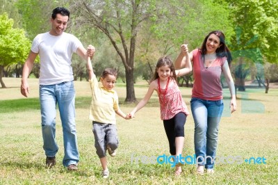 Family Walking In The Park Stock Photo