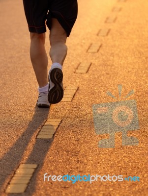 Feet Of Runner In Evening Light Stock Photo