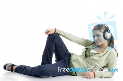 Female Lying And Listening Music Stock Photo