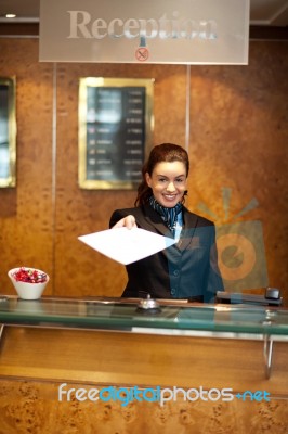 Female Receptionist Giving Paper Stock Photo