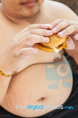 Ffat Man Eating Hamburger Seated Stock Photo