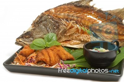 Fish Fried With Spicy Mango Salad In The Black Plate Stock Photo