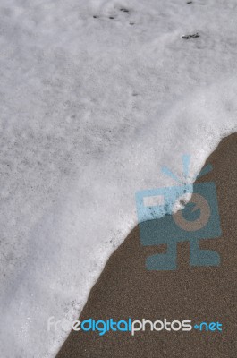 Foam On Sand Stock Photo