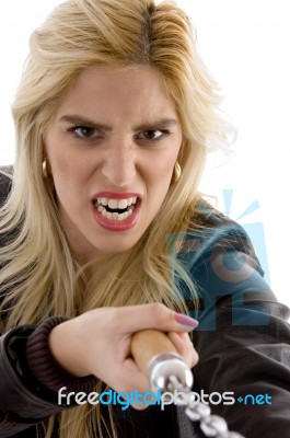 Front View Of Violent Young Woman Holding Nunchaku Stock Photo
