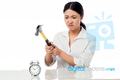 Frustrated Woman Smashing An Alarm Clock Stock Photo