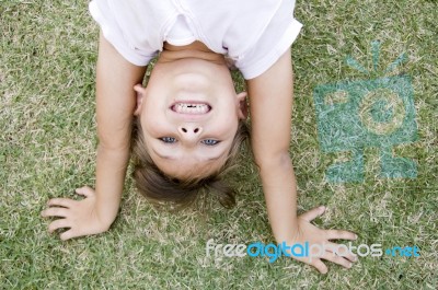 Girl Doing Cartwheel In The Grass Stock Photo