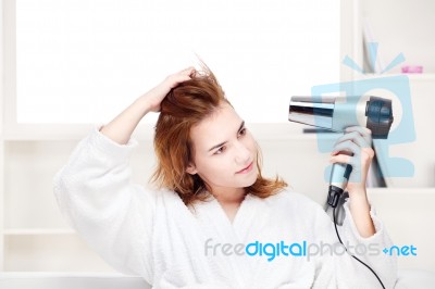 Girl Drying Her Hair At Home Stock Photo