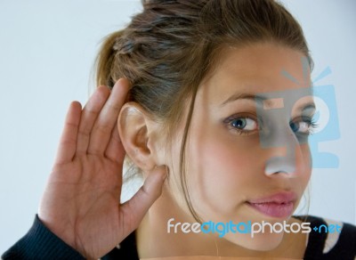 Girl Listens With Hand At Ear Stock Photo