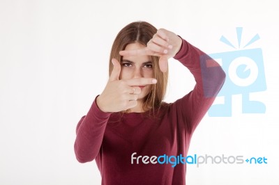Girl Looks In The Frame Of Her Hands Stock Photo