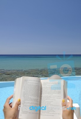 Girl Reading A Book On A Beach Stock Photo