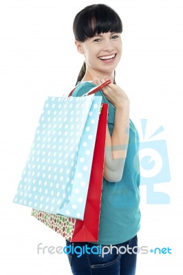 Girl With Shopping Bags Tossed Over Her Shoulders Stock Photo