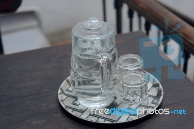 Glasses Of Water Are Placed On A Plate At The Wooden Table Stock Photo