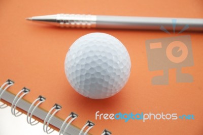 Golf Ball On Notebook Stock Photo