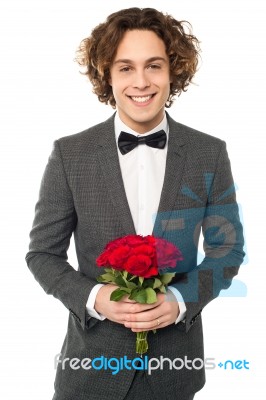 Groom In Tuxedo Posing With A Bouquet Stock Photo