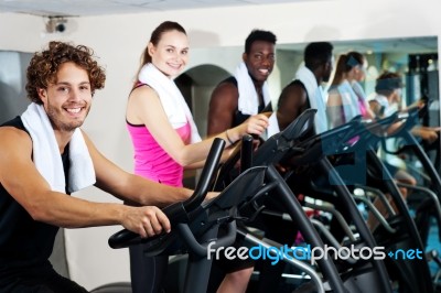 Group Of Friends Cycling In Gym Stock Photo