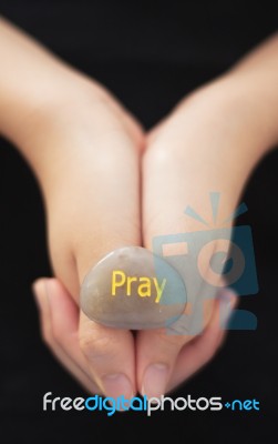 Hand Holding Engraved Pray Stone Stock Photo