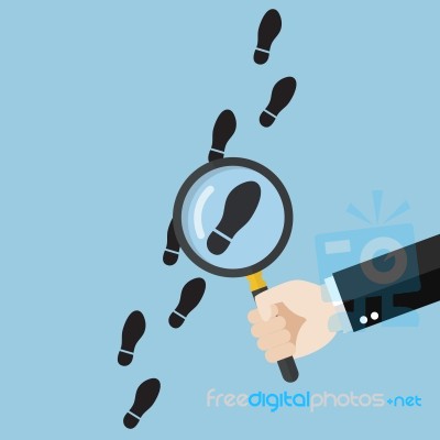 Hand Holding Magnifying Glass Over Footsteps Stock Image
