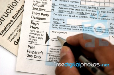 Hand Signing A Tax Form Stock Photo