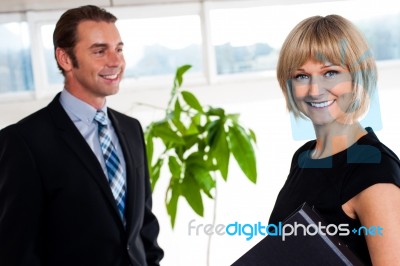 Handsome Boss Passing By Smiling Female Colleague Stock Photo