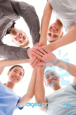 Happy Businesspeople Placing Their Hands Top Of Each Other Stock Photo