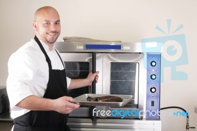 Happy Chef Taking His Freshly Baked Rib-eye Steak Stock Photo