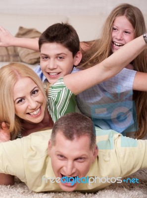 Happy Family Lying On Top Of Each Other Stock Photo