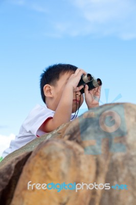 Happy Little Boy Exploring Outdoors Clambering On A Rock With Te… Stock Photo