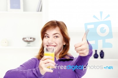Happy Teenage Girl Drinks Orange Juice At Home Stock Photo