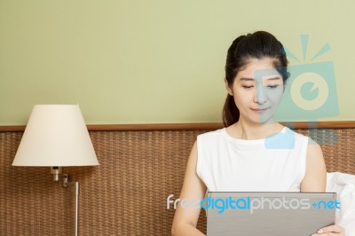 Happy Young Asian Woman Working With Laptop In Bedroom Stock Photo