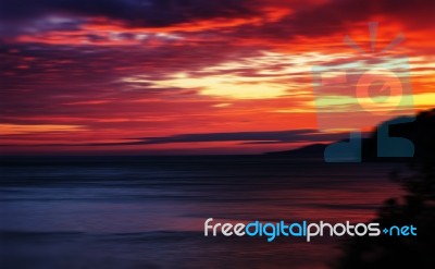 Horizontal Vivid Red Orange Vibrant Sunset Ocean Horizon Motion Stock Photo