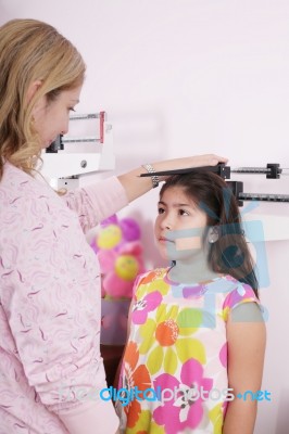 Lady Doctor Measuring Girls Height Stock Photo