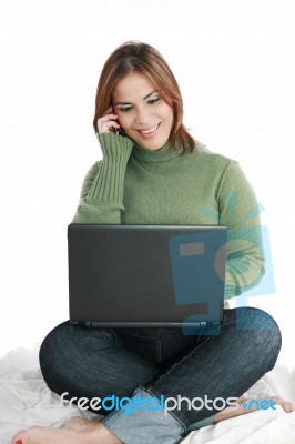Lady Using Laptop And Phone Stock Photo