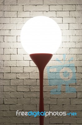 Lamp With Circle Shape On White Bricks Background Vertical Stock Photo