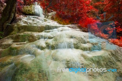 Lime Stone Water Falls And Red Leaves Plant Stock Photo