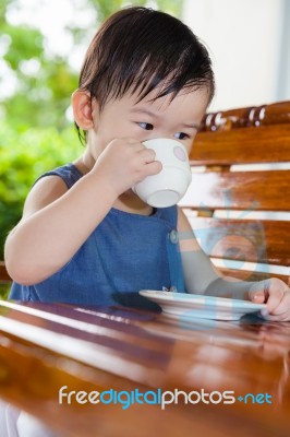 Little Asian Girl (thai) Drinking From A Cup Stock Photo