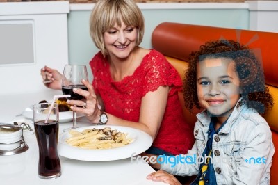 Little Girl Enjoying Dinner With Her Mom Stock Photo