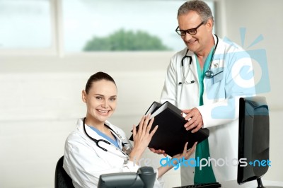 Male Doctor Handing Over Files Stock Photo