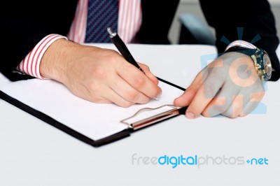 Male's Hand Writing On Blank Notepad Stock Photo