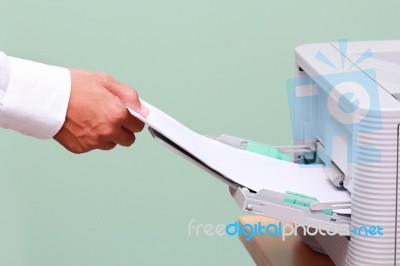 Man Fixing Paper Into Printer Stock Photo